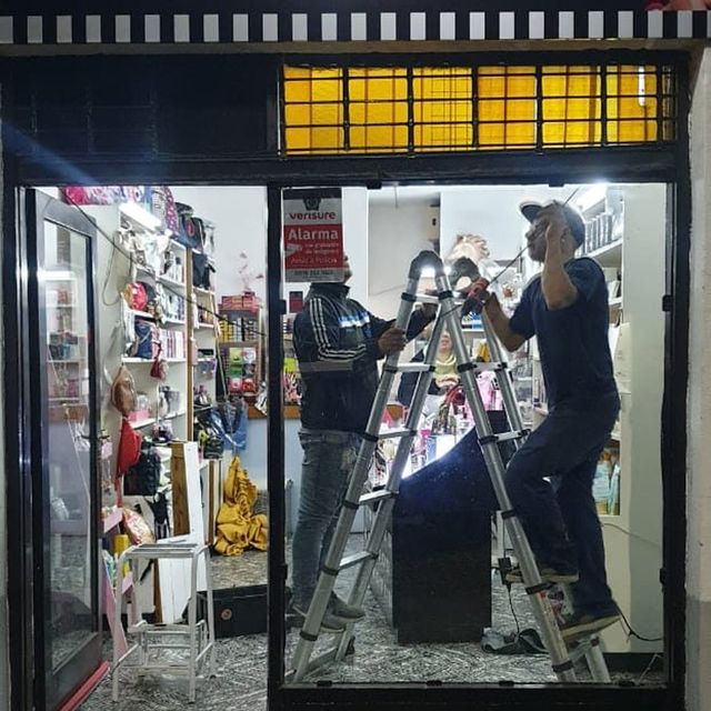 Técnicos reparando la cortina de una perfumería de noche en Rosario